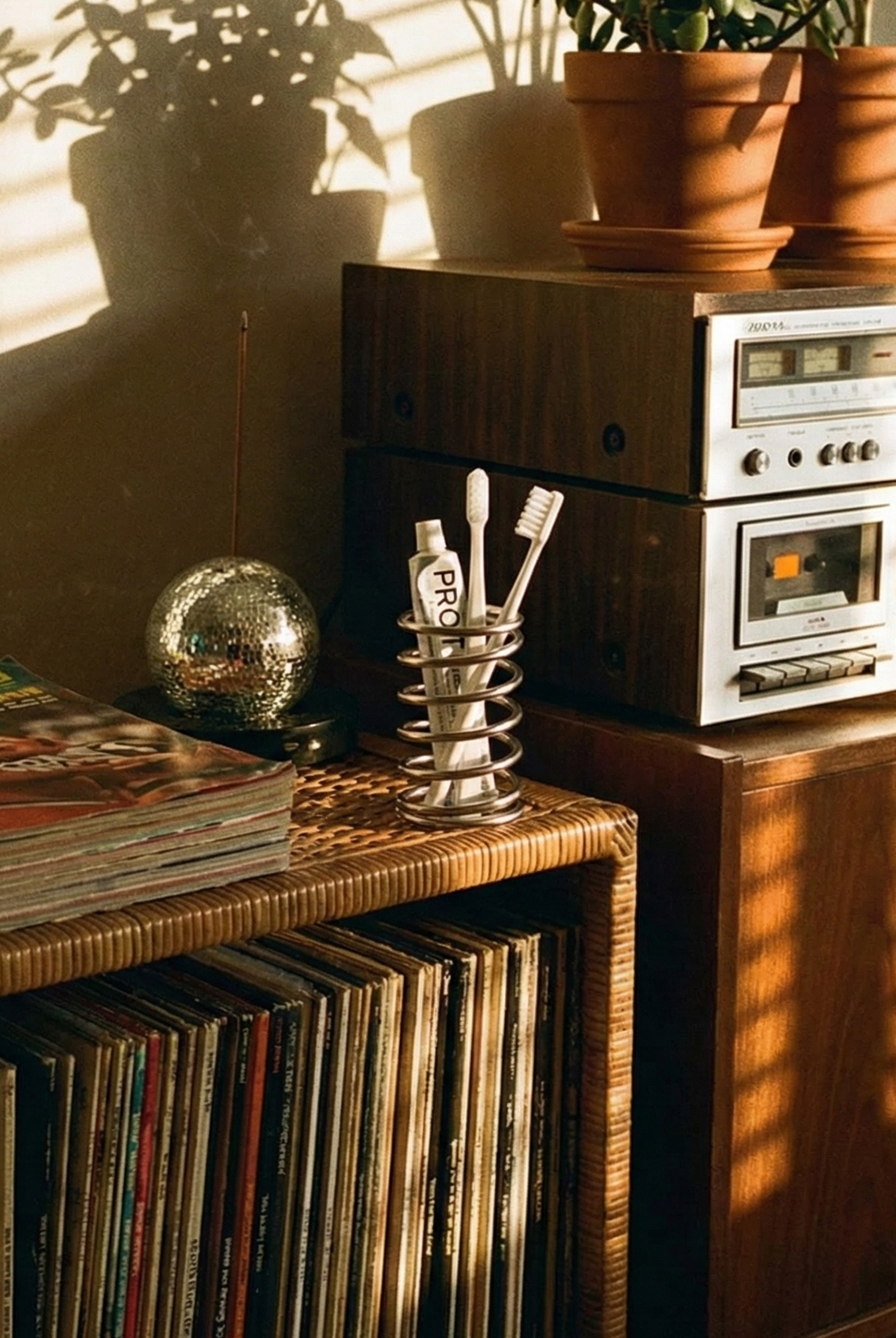 Vintage stereo system with vinyl records and a magazine on a wooden cabinet.