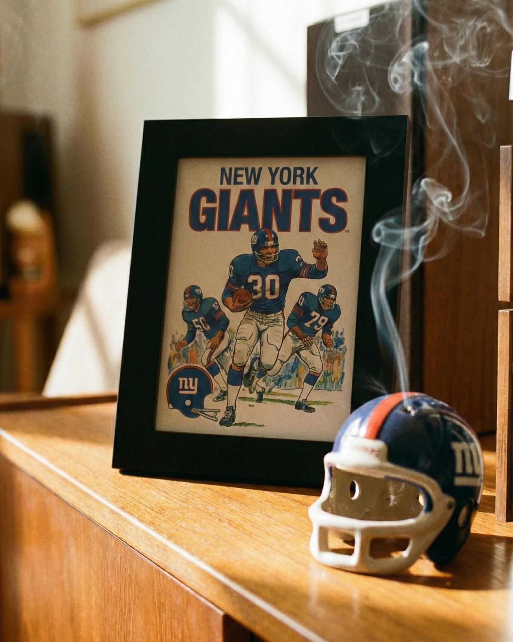 Framed New York Giants poster with a helmet on a wooden surface
