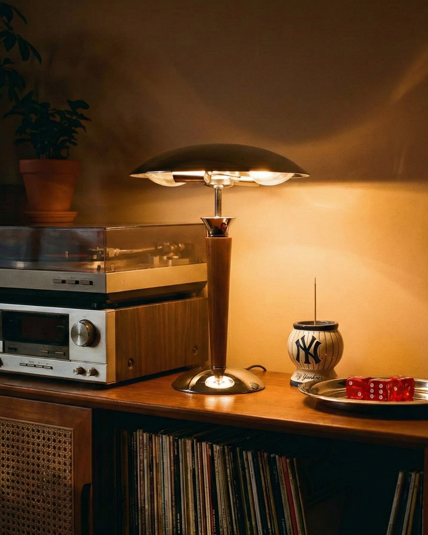 Vintage stereo system with a lamp and decorative items on a wooden shelf.