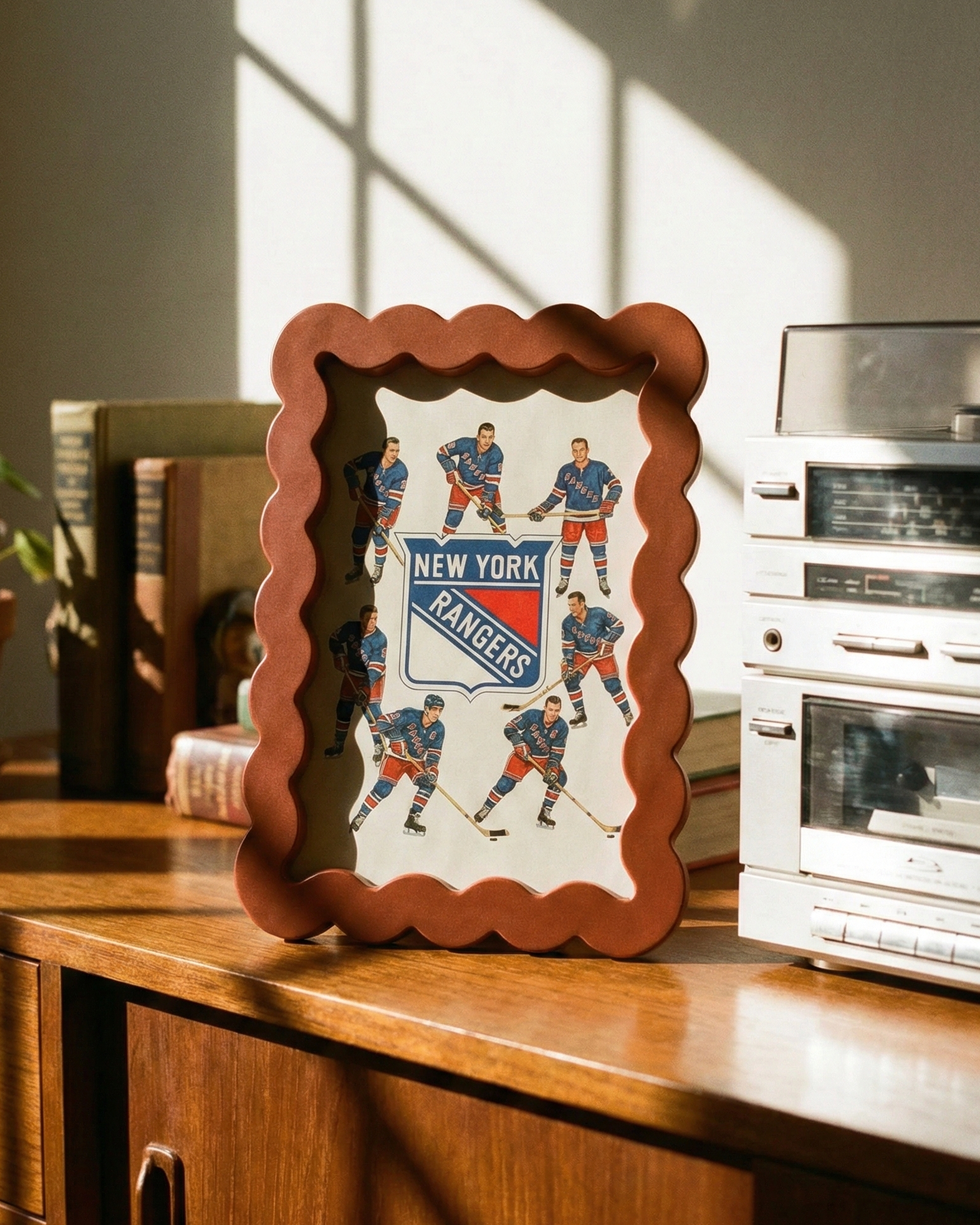 Framed New York Rangers poster on a wooden surface with vintage stereo equipment in the background.