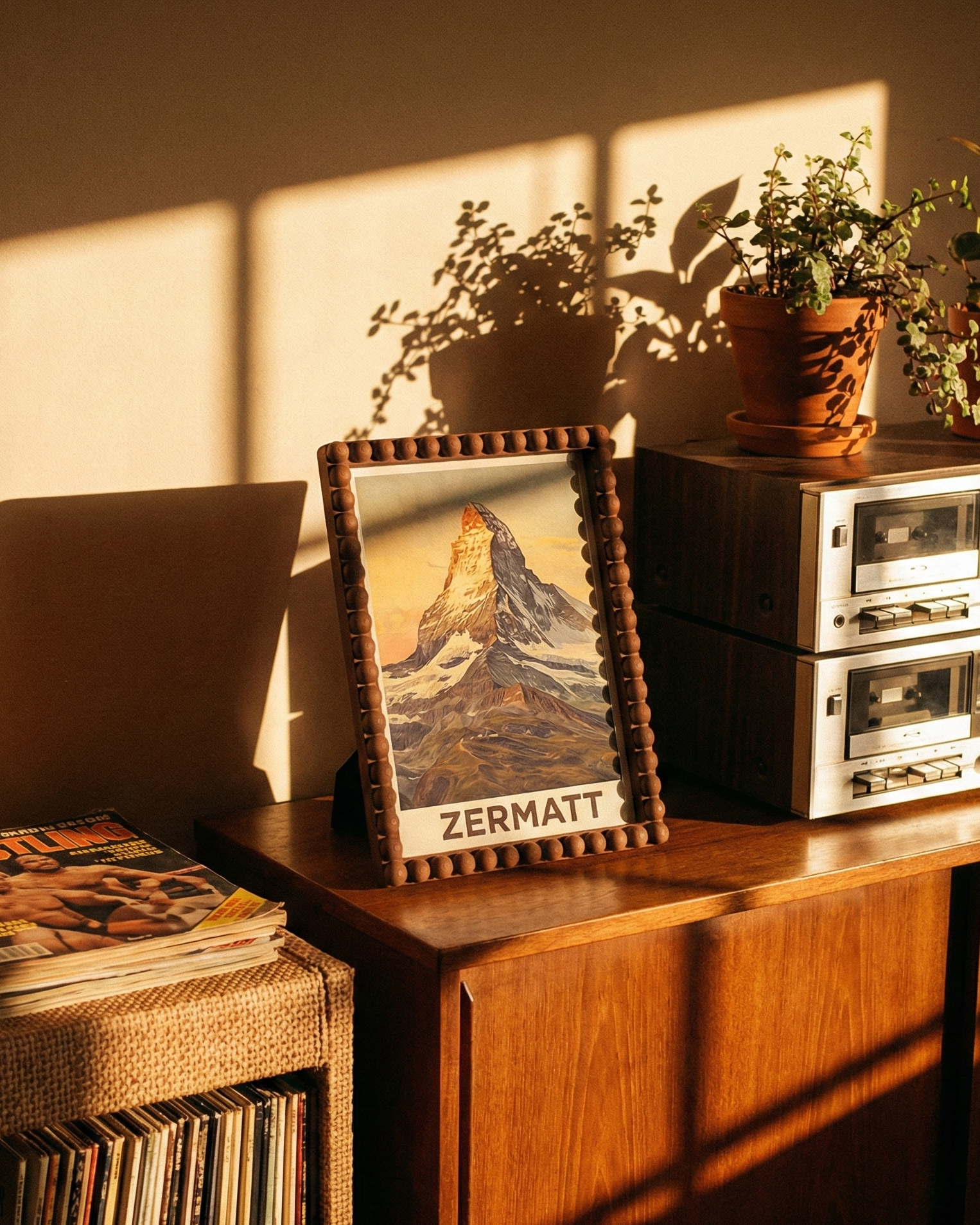 Wooden sideboard with vinyl records, framed picture, and vintage stereo equipment in a warm-lit room.