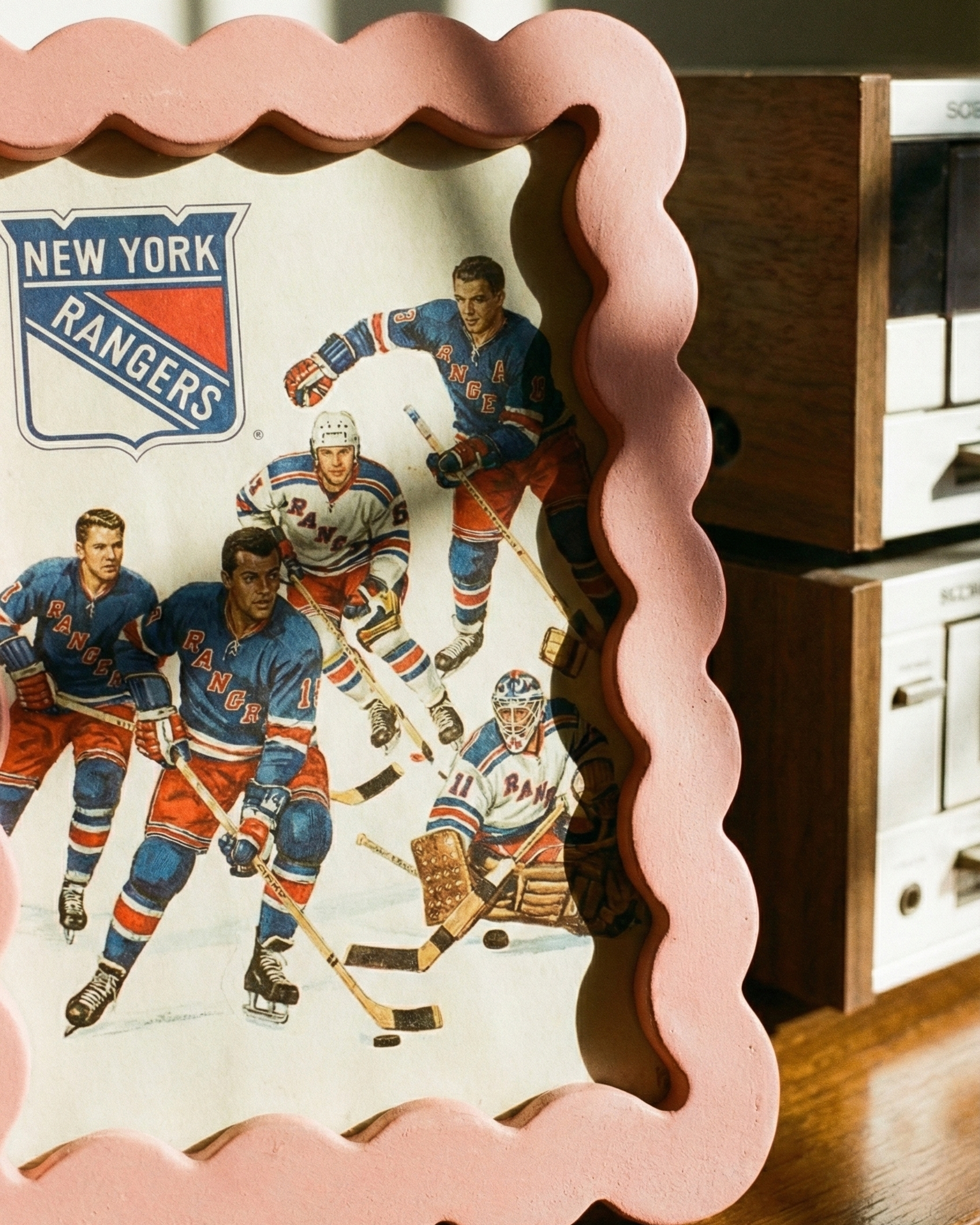 Decorative wall art with New York Rangers hockey players on a wooden surface.