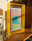 Framed artwork with 'New York' text on a wooden surface