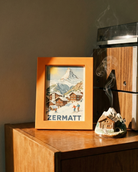 Wooden cabinet with a framed picture of Zermatt and a vintage radio.