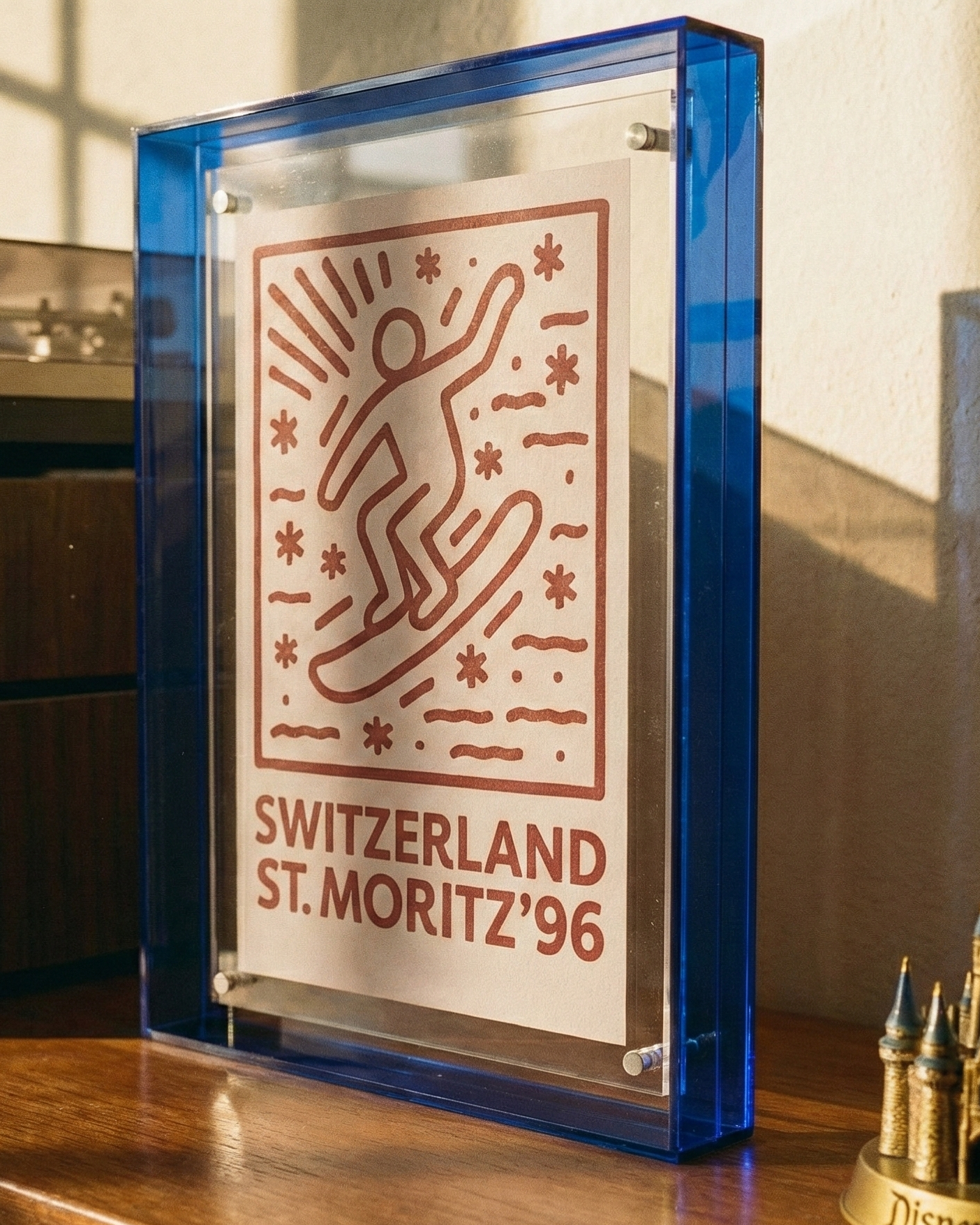 Decorative plaque with 'Switzerland St. Moritz '96' design on a wooden surface.
