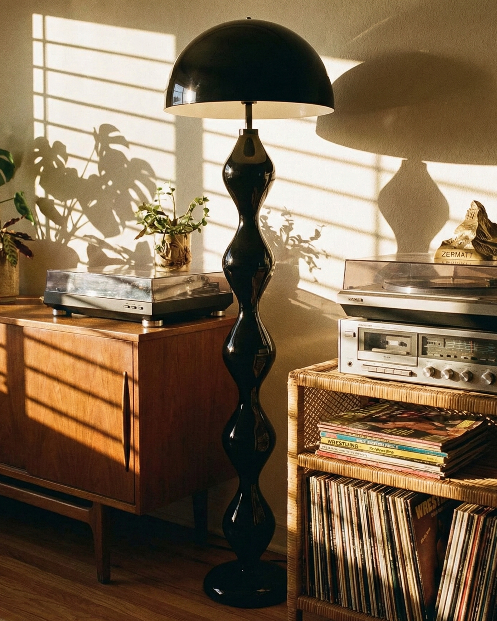 Vintage stereo equipment with vinyl records and a black floor lamp in a sunlit room.